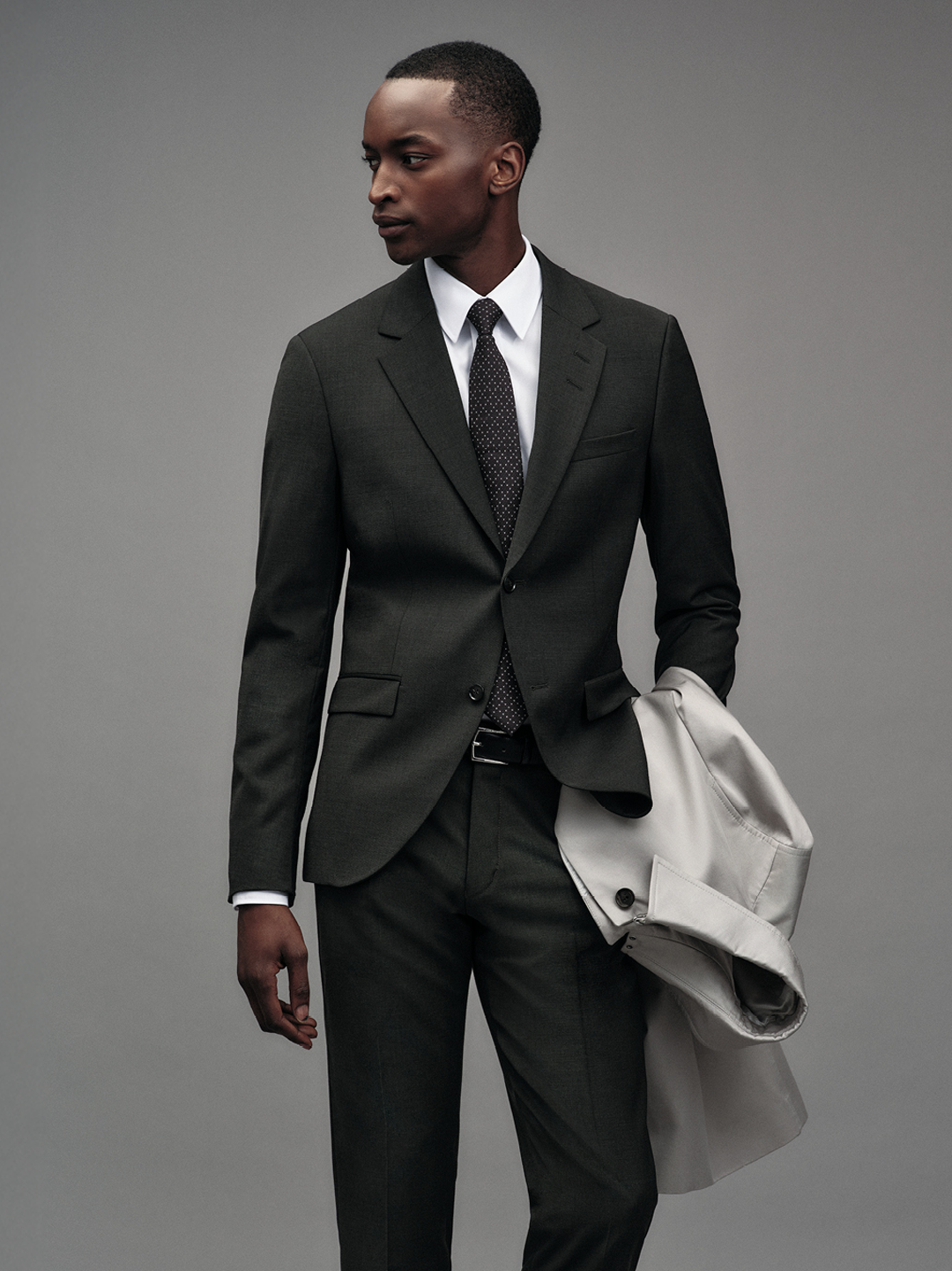 Man in black suit with beige coat
